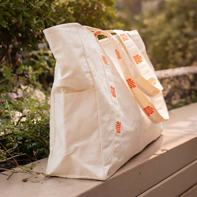 Bolsa Tote Ollie Leve seu Protetor Solar Ollie onde for com nossa Tote Bag! Feita em lona, fácil de limpar, com bolsos laterais e internos, perfeita para qualquer look.
