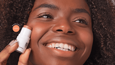 Bastão três em um sendo aplicado como blush.